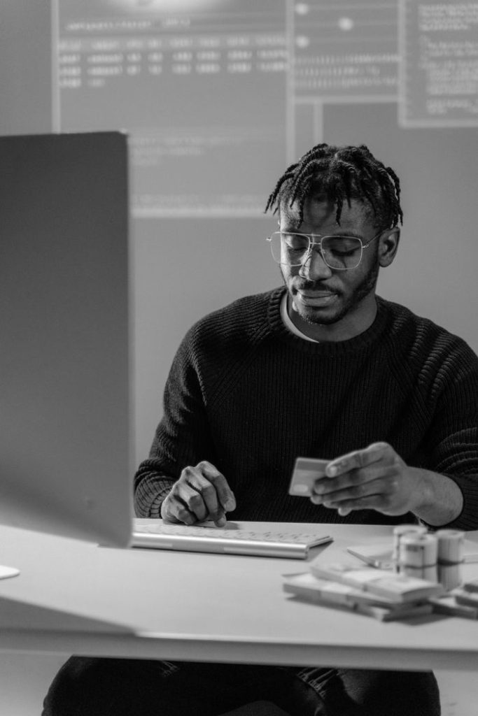 A man intensely reviews financial data and card details, indicating cybersecurity awareness.